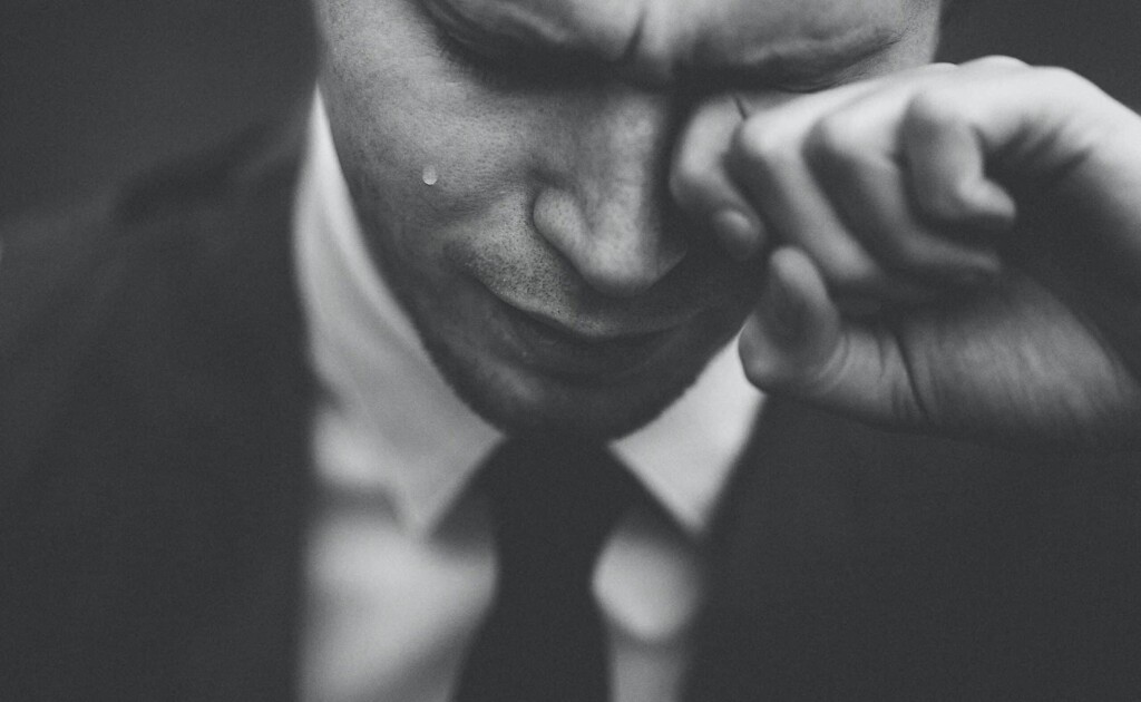 Man in suit and tie crying